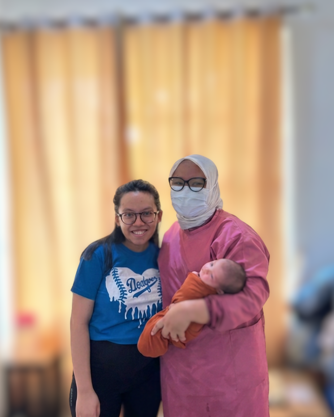 Gardenia midwife holding a baby beside the mother
